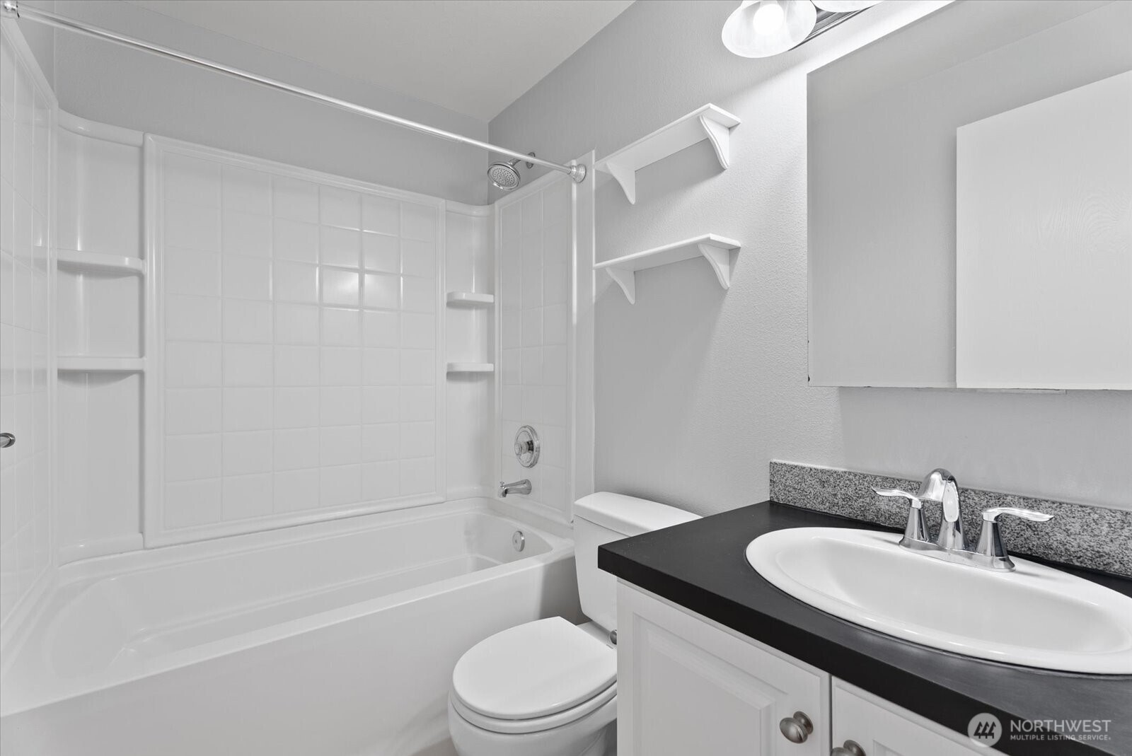 1109 North Allen Place, Unit 205 Seattle, WA 98103 - Photo 13 of 26 a bathroom with a granite countertop sink toilet a mirror and shower