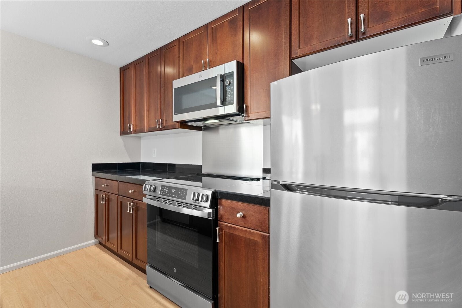 1109 North Allen Place, Unit 205 Seattle, WA 98103 - Photo 6 of 26 a kitchen with a stove and a microwave