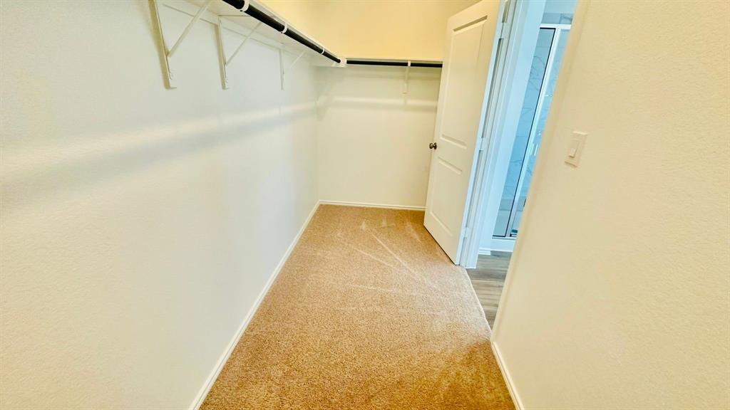 192 Rodney Boat Road Kyle, TX 78640 - Photo 27 of 38 Functional closet space offers carpeted flooring and efficient clothing rods for storage.