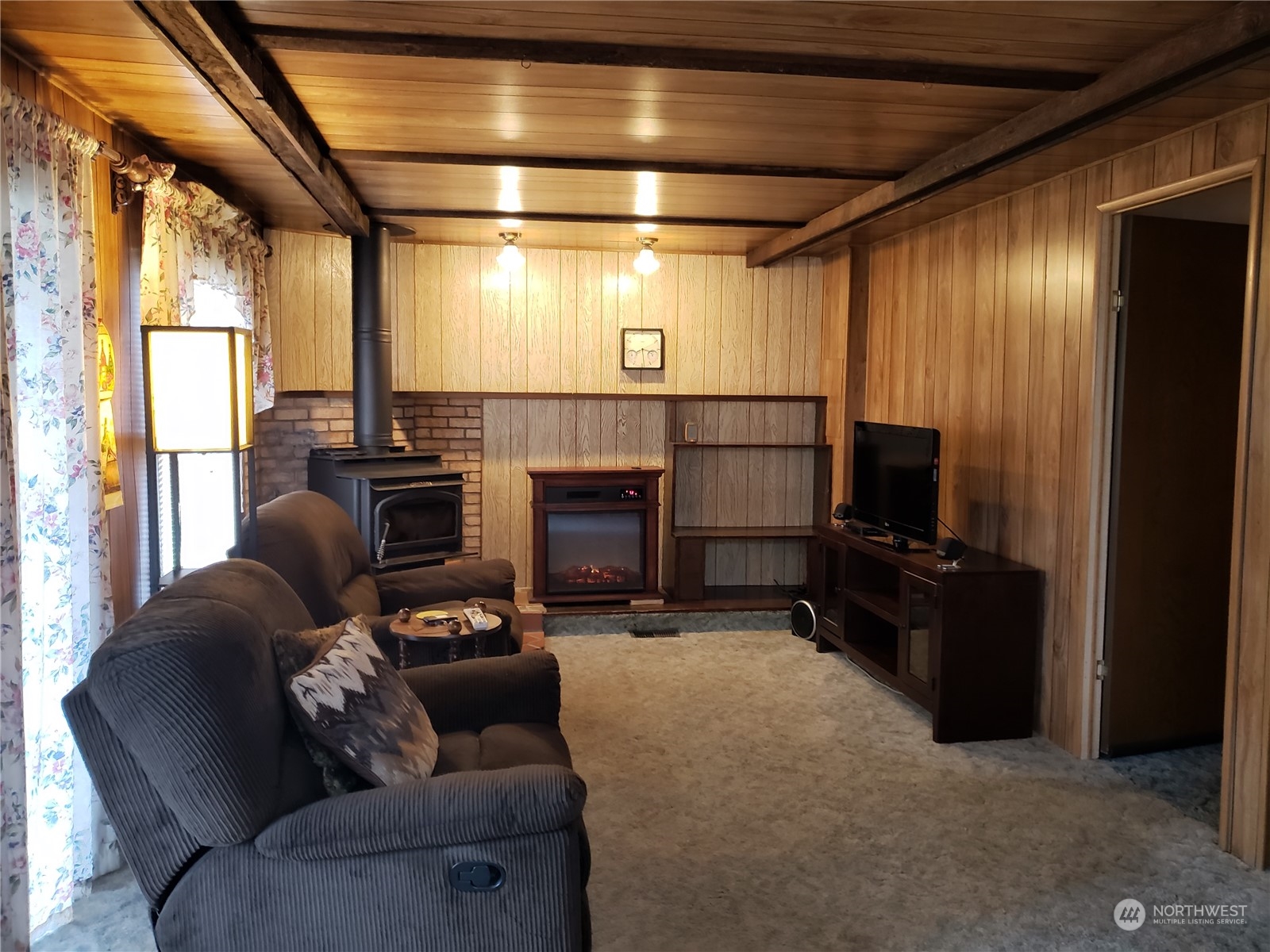 1080 Pine Drive Enumclaw, WA 98022 - Photo 7 of 36 a living room with furniture a flat screen tv and a fireplace