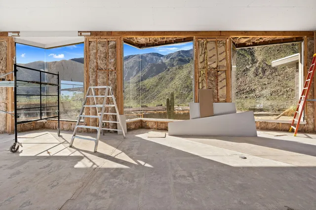 a living room with a large window and furniture