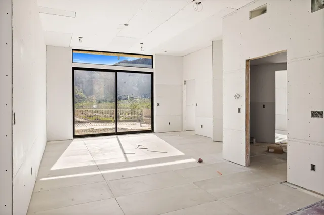 a bed sitting in a bedroom next to a large window