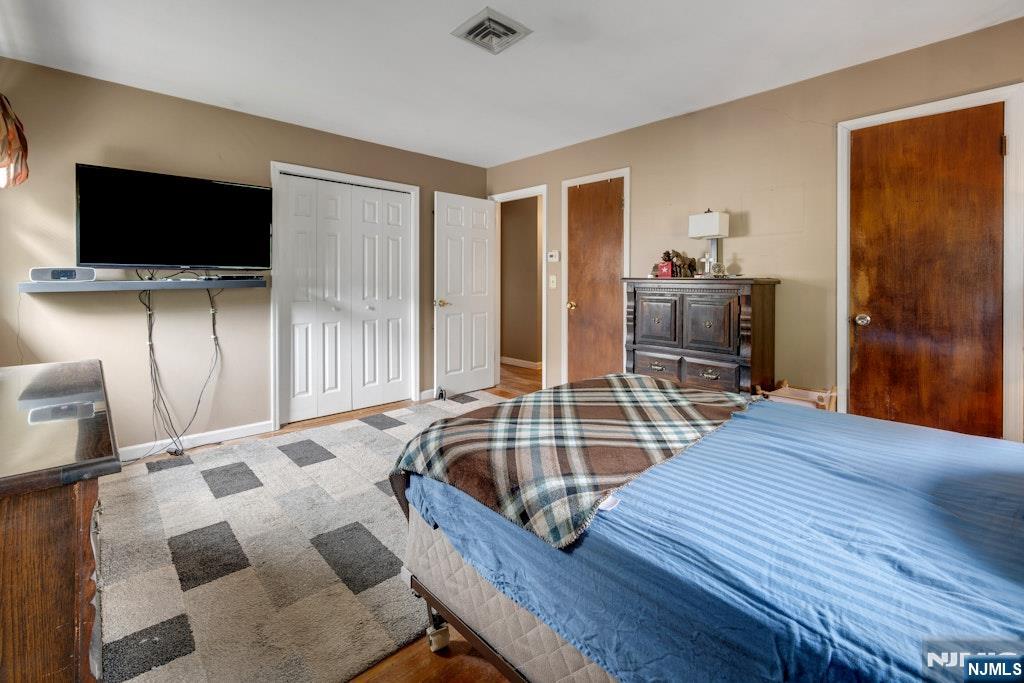 185 Ratzer Road Wayne, NJ 07470 - Photo 30 of 36 a bedroom with a bed and a flat screen tv