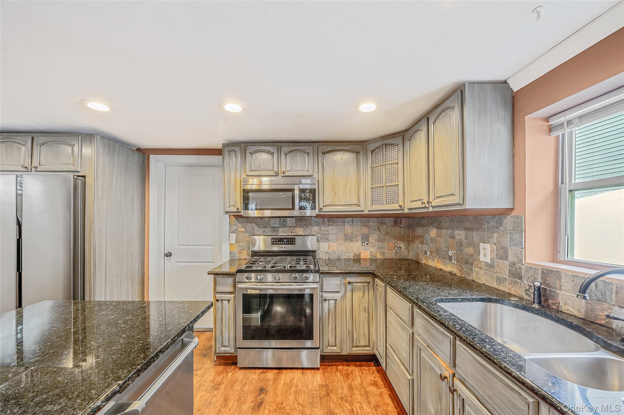93 Maple Road Kings Park, NY 11754 - Photo 12 of 24 a kitchen with granite countertop stainless steel appliances a stove sink and refrigerator