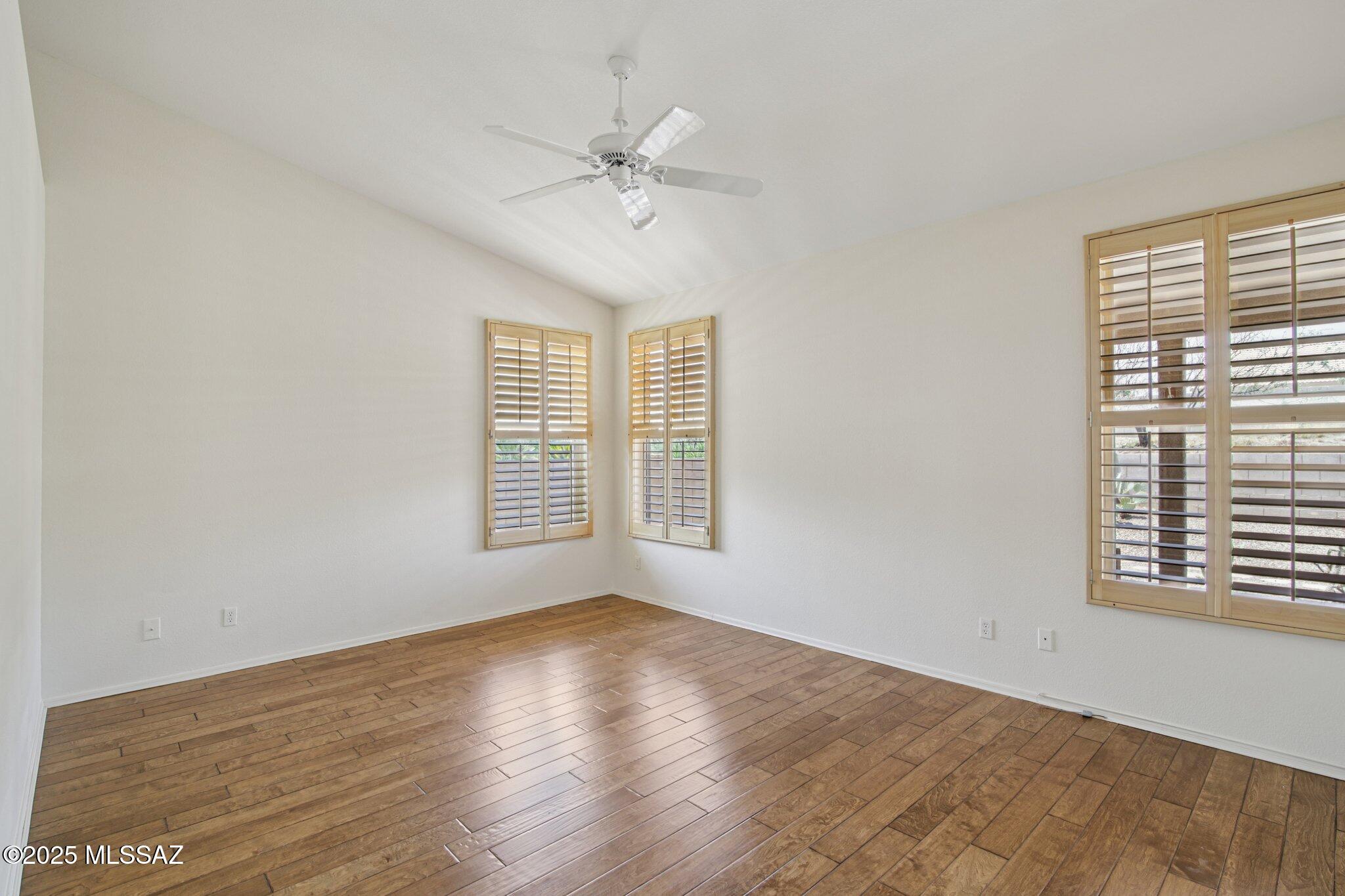 35890 Mesa Ridge Drive Tucson, AZ 85739 - Photo 14 of 31 a view of an empty room with wooden floor and a window