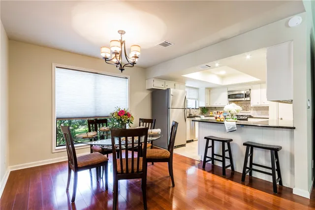 a view of a dining room with furniture wooden floor and chandelier