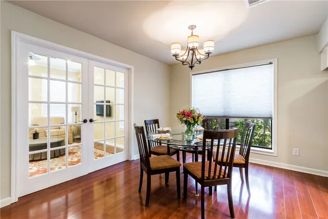a view of a dining room with furniture a chandelier and wooden floor