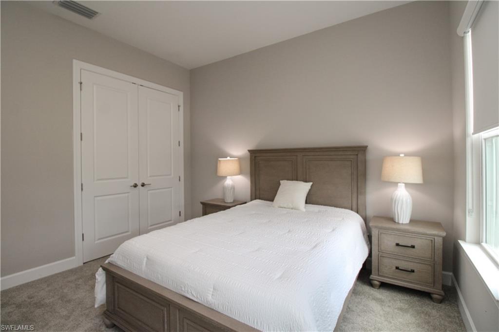 15765 Cortina Street Naples, FL 34114 - Photo 13 of 50 a bedroom with a bed and a lamp
