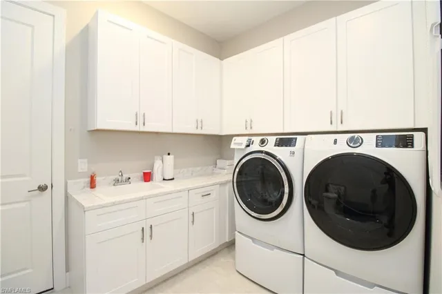 a utility room with sink dryer and washer
