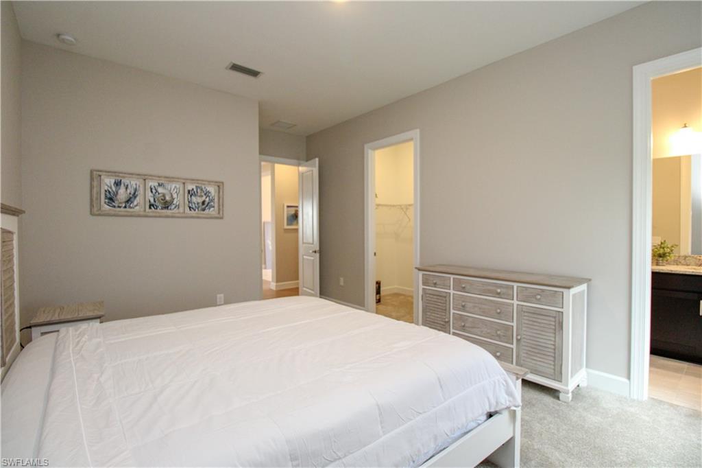 15765 Cortina Street Naples, FL 34114 - Photo 20 of 50 a bedroom with a large bed and a window