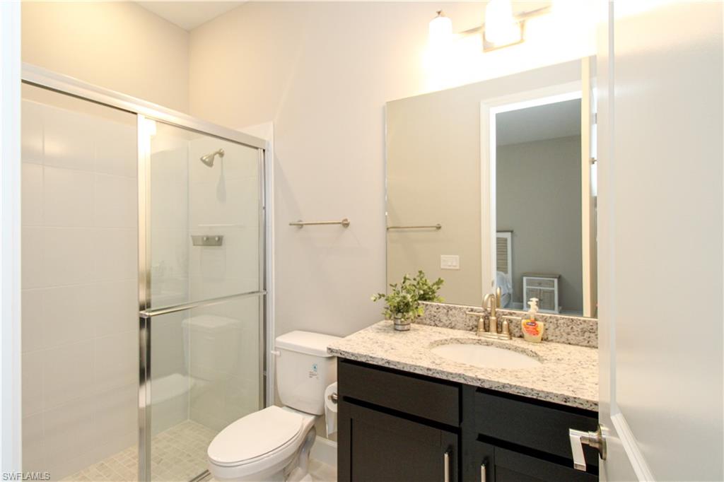15765 Cortina Street Naples, FL 34114 - Photo 22 of 50 a bathroom with a granite countertop sink toilet and shower