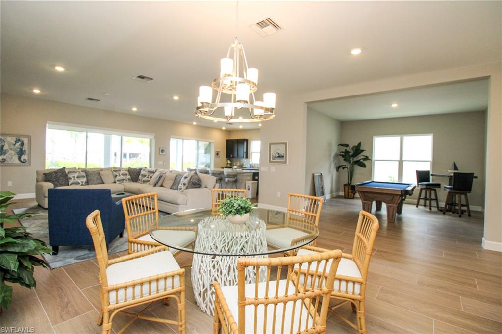 15765 Cortina Street Naples, FL 34114 - Photo 24 of 50 a view of a dining room with furniture and wooden floor