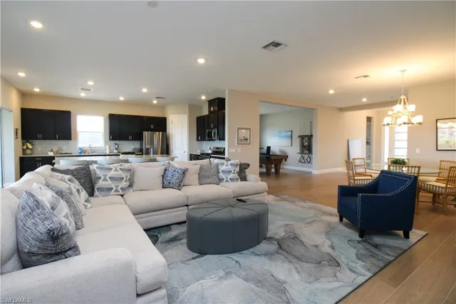 a living room with furniture and a view of kitchen