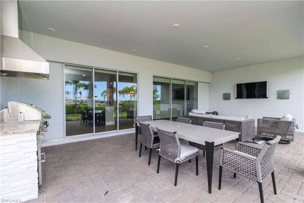 15765 Cortina Street Naples, FL 34114 - Photo 3 of 50 a view of a dining room with furniture and wooden floor
