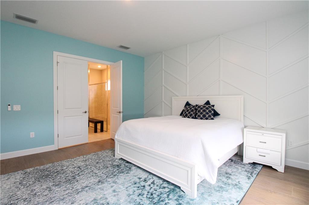15765 Cortina Street Naples, FL 34114 - Photo 34 of 50 a bedroom with a bed and wooden floor