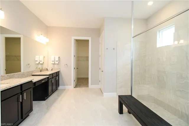 a large bathroom with a granite countertop sink a toilet a mirror and shower