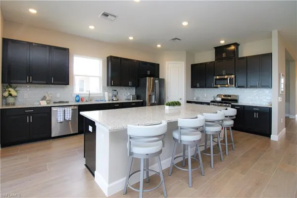 a kitchen with stainless steel appliances a stove a sink a microwave a refrigerator and cabinets