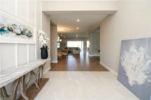 a view of a hallway with wooden floor and a living room