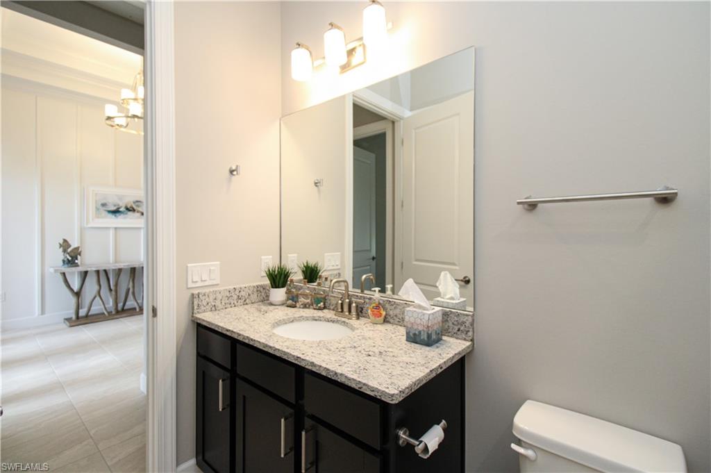 15765 Cortina Street Naples, FL 34114 - Photo 9 of 50 a bathroom with a sink vanity and a mirror
