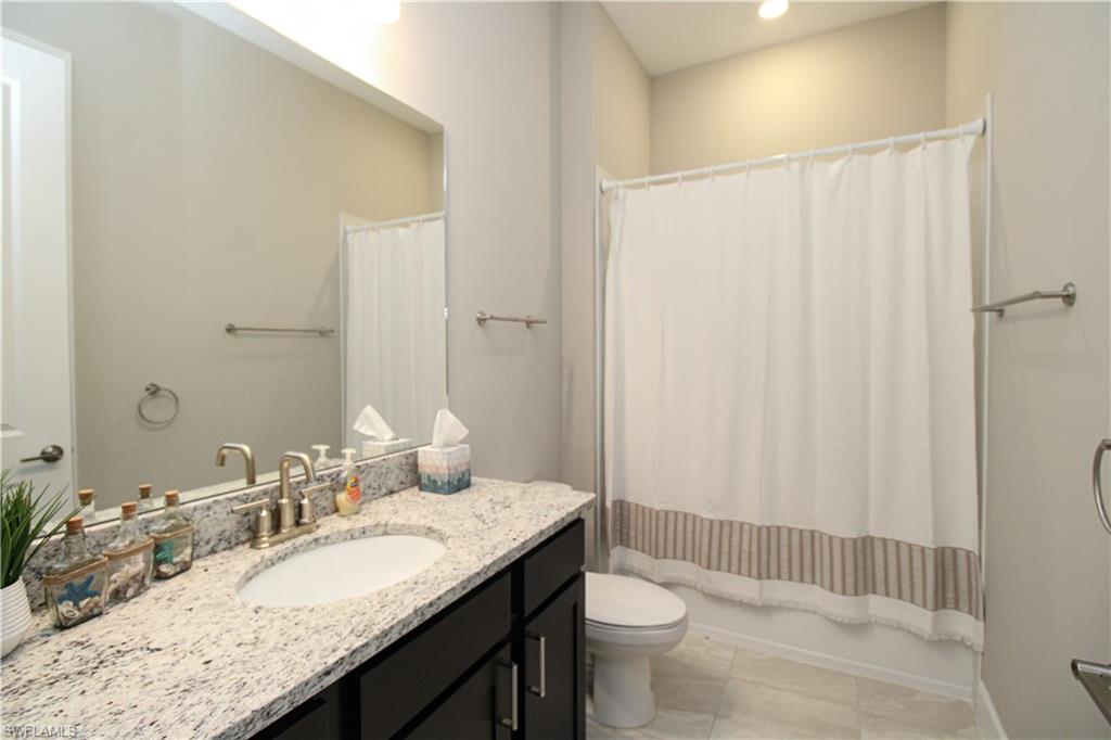 15765 Cortina Street Naples, FL 34114 - Photo 10 of 50 a bathroom with a granite countertop sink and a mirror