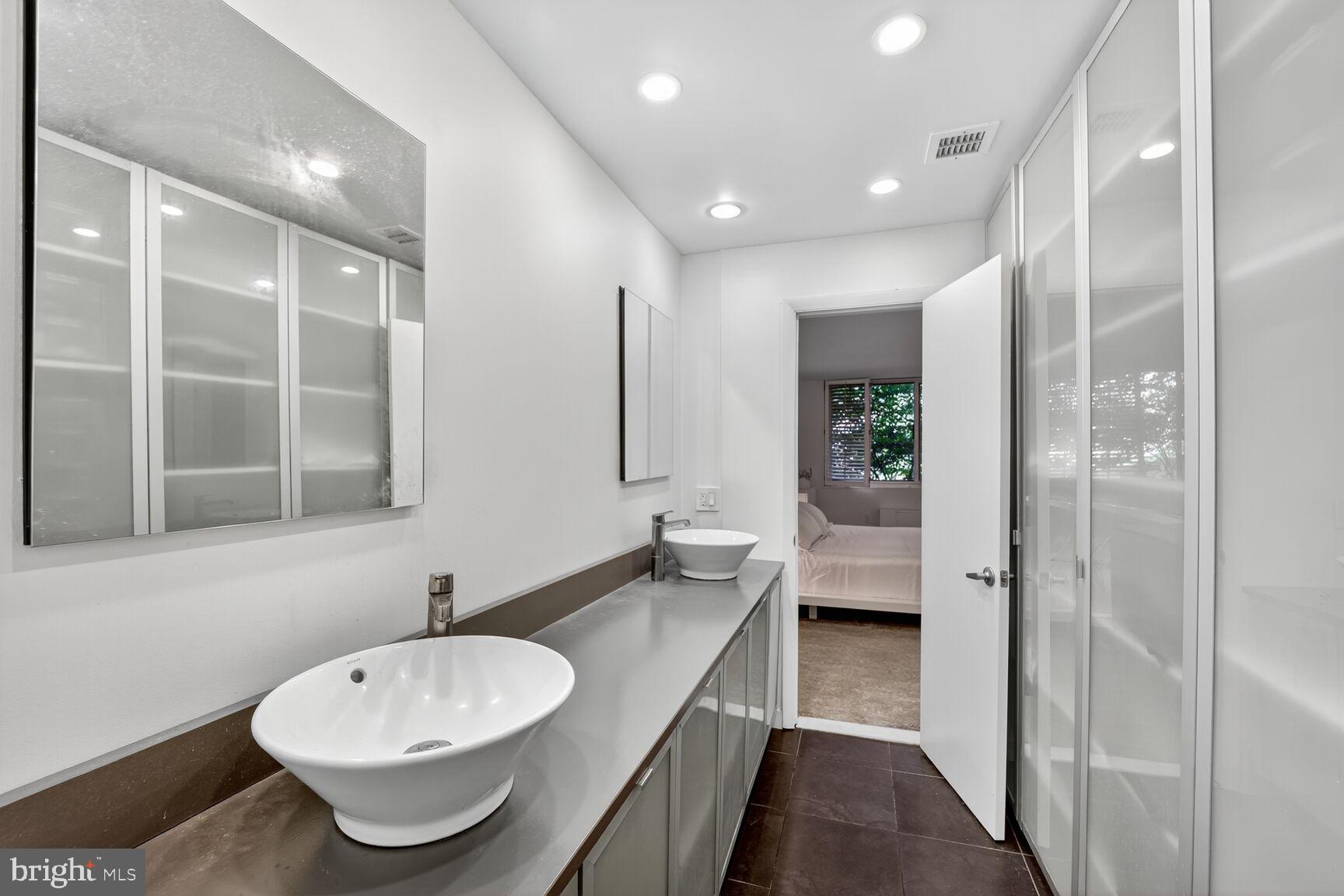 4100 Cathedral Avenue Northwest, Unit 615 Washington, DC 20016 - Photo 12 of 26 a bathroom with a double vanity sink and a mirror
