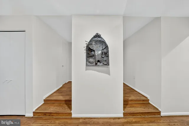 a view of a hallway with wooden floor and entryway