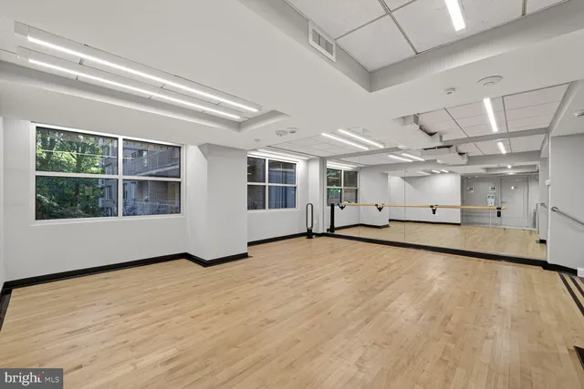 a view of an empty room with a window and chandelier