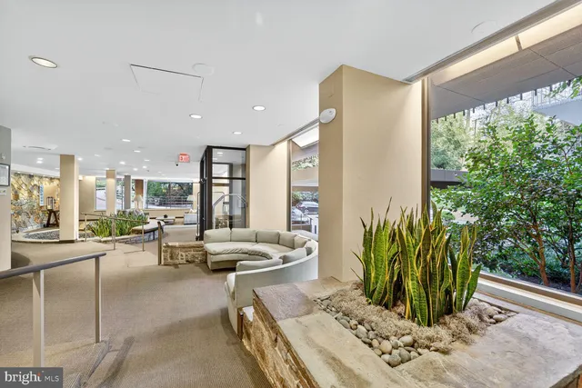 a living room with patio furniture and a potted plant