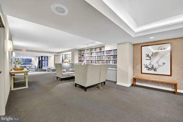 a living room with furniture and a book shelf