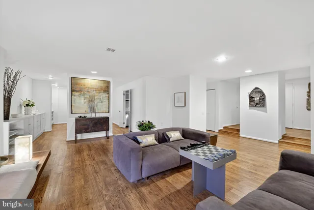 a living room with furniture and wooden floor