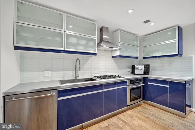 a kitchen with stainless steel appliances granite countertop a sink stove and cabinets