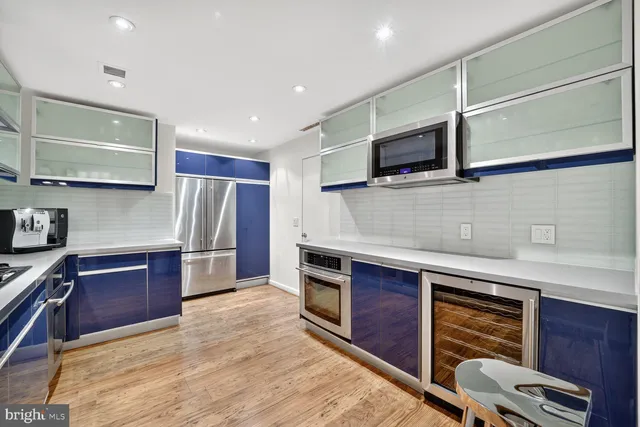 a kitchen with stainless steel appliances granite countertop a refrigerator a stove and a sink