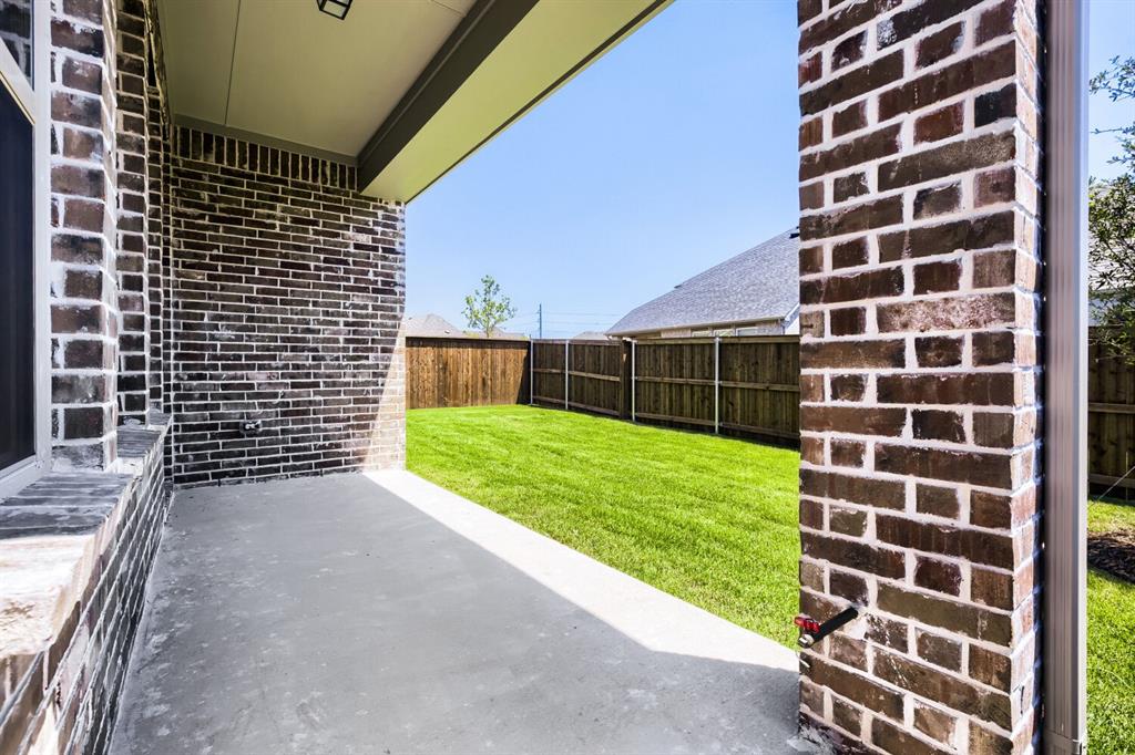824 Stone Grv Road Lavon, TX 75166 - Photo 22 of 26 Covered patio with a concrete surface, a dark brick exterior, and a manicured lawn