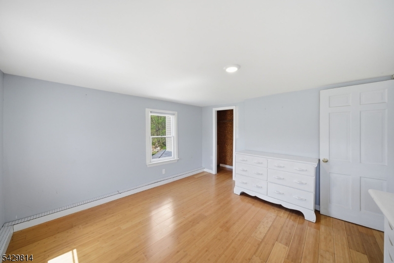 251 Russia Road Oak Ridge, NJ 07438 - Photo 23 of 34 an empty room with wooden floor and windows