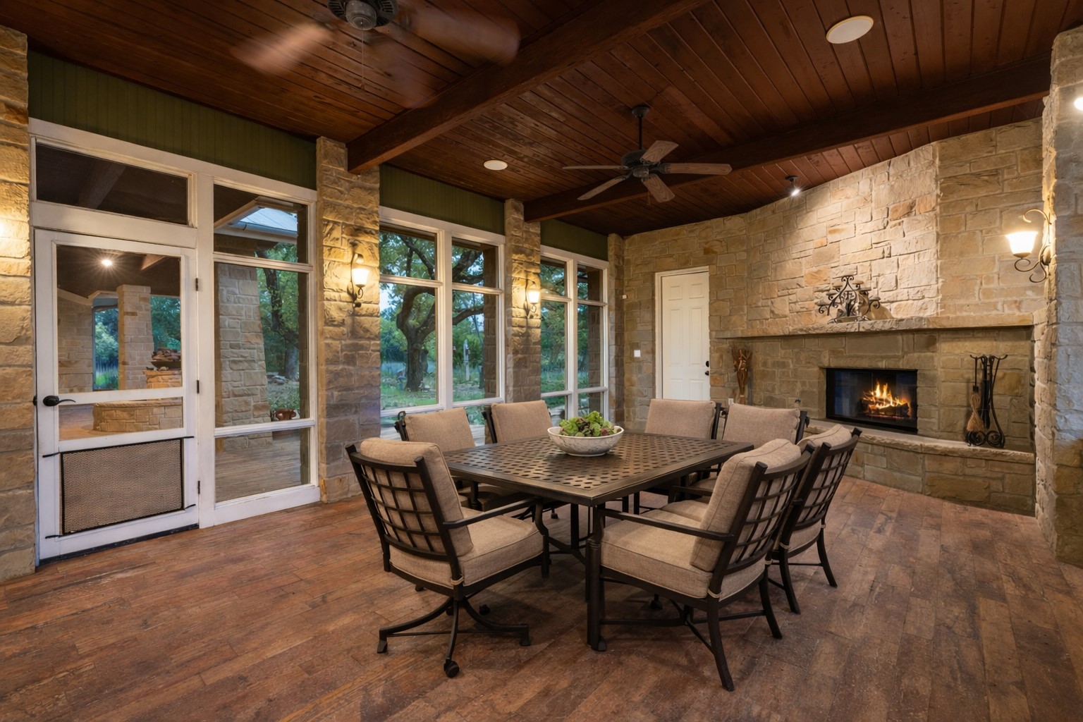 23426 Oscar Road Spicewood, TX 78669 - Photo 19 of 40 Off the kitchen is an amazing screened-in porch that features a stone fireplace and a built-on grill. The fireplace has a full length hearth and mantle.