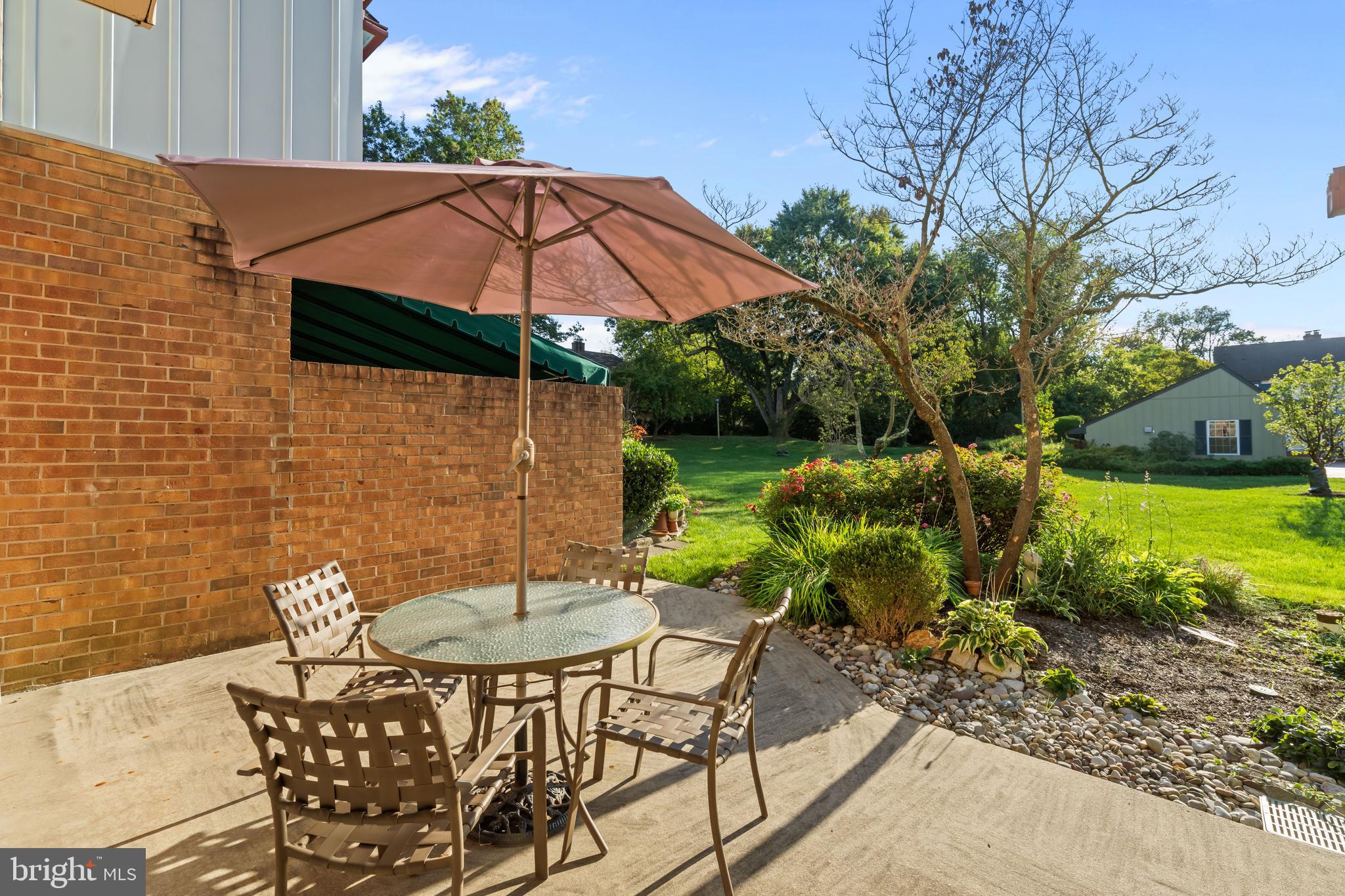 633 East Main Street, Unit B7 Moorestown, NJ 08057 - Photo 37 of 42 a backyard of a house with table and chairs under an umbrella
