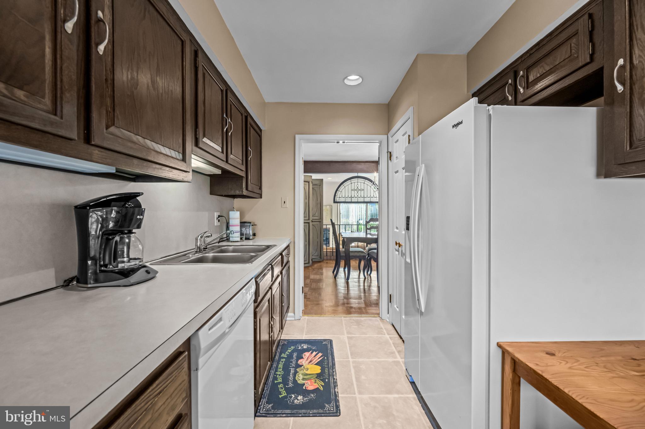 633 East Main Street, Unit B7 Moorestown, NJ 08057 - Photo 10 of 42 a kitchen with stainless steel appliances granite countertop a refrigerator a stove and a sink with wooden cabinets
