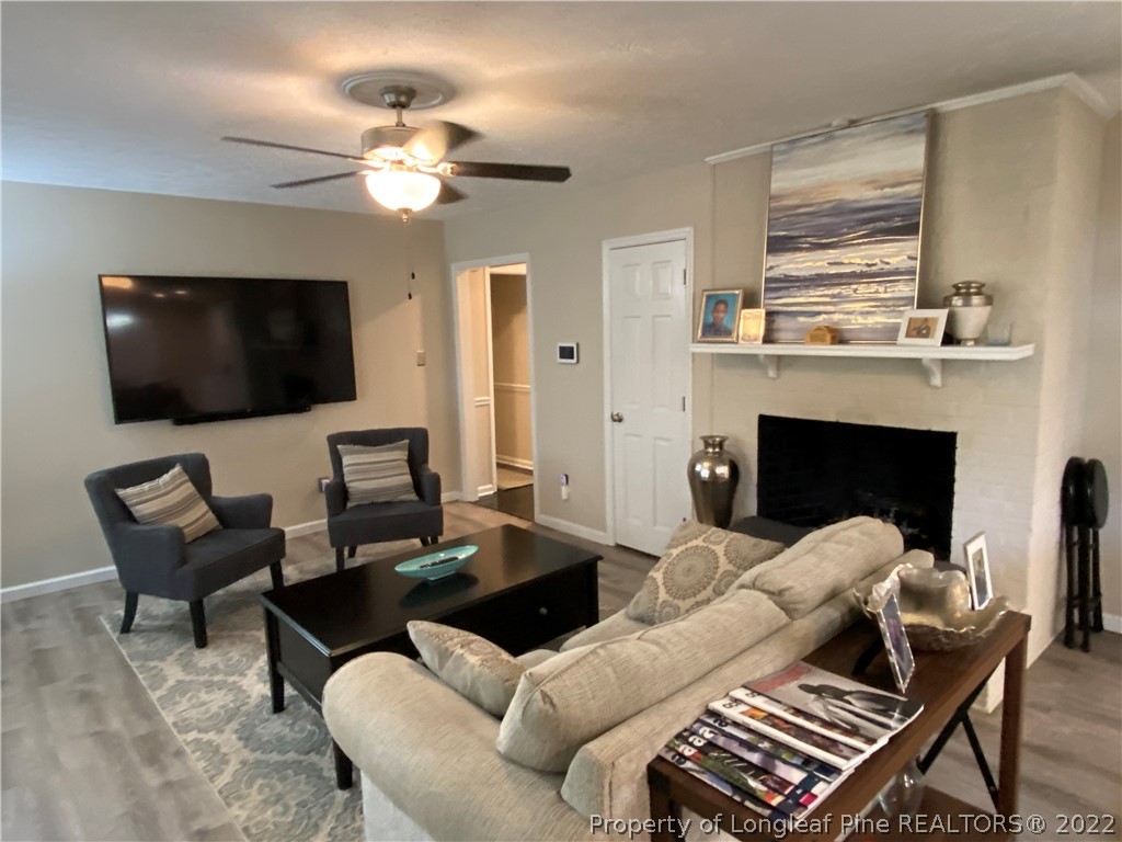 215 Rivenoak Drive Fayetteville, NC 28303 - Photo 11 of 21 a living room with furniture a flat screen tv and a fireplace