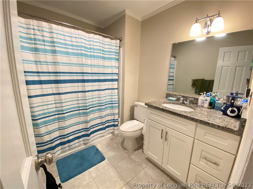 215 Rivenoak Drive Fayetteville, NC 28303 - Photo 13 of 21 a bathroom with a sink a toilet a mirror and shower curtain
