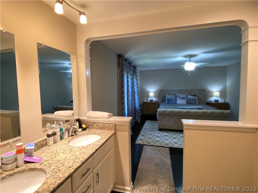 215 Rivenoak Drive Fayetteville, NC 28303 - Photo 17 of 21 a bathroom with a granite countertop sink and a large mirror