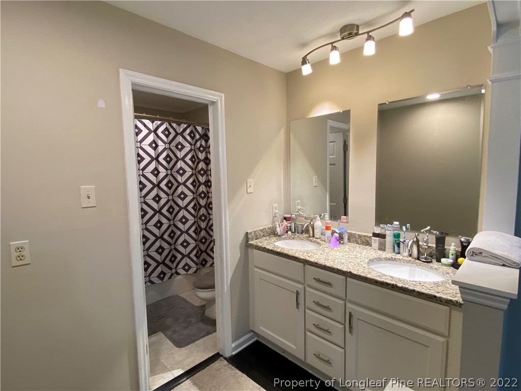 215 Rivenoak Drive Fayetteville, NC 28303 - Photo 18 of 21 a bathroom with a shower sink and mirror