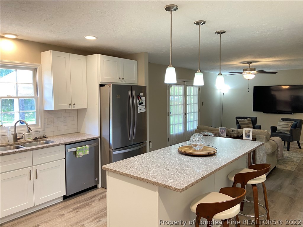 215 Rivenoak Drive Fayetteville, NC 28303 - Photo 6 of 21 a kitchen with kitchen island a sink table and chairs
