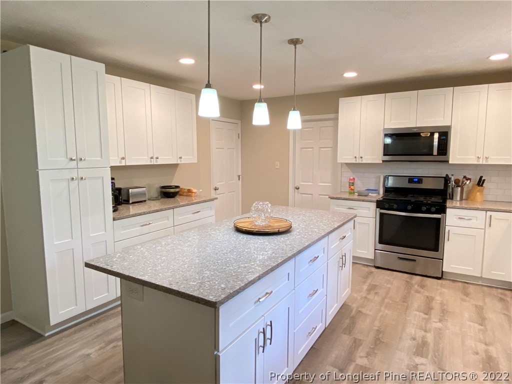 215 Rivenoak Drive Fayetteville, NC 28303 - Photo 8 of 21 a kitchen with stainless steel appliances granite countertop a stove a sink and a refrigerator