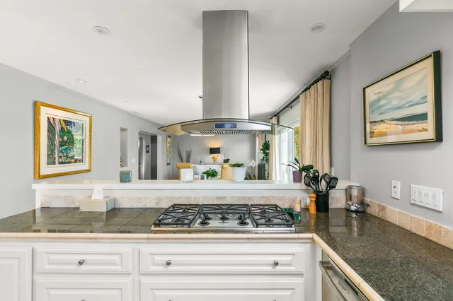 a kitchen with granite countertop white cabinets and window