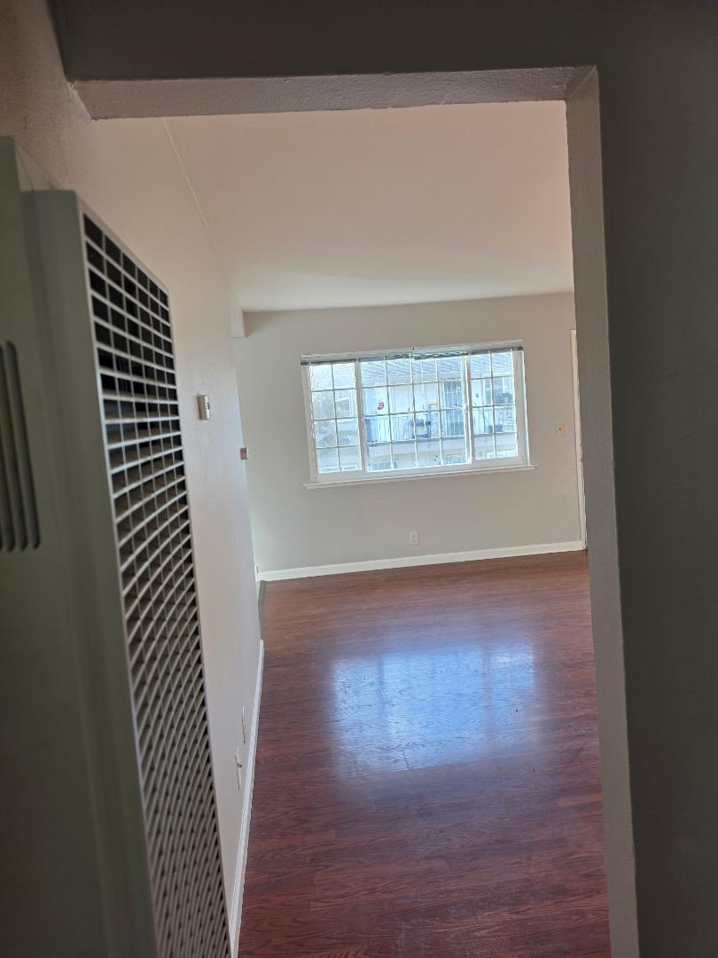5745 Almaden Road, Unit D San Jose, CA 95118 - Photo 3 of 11 an empty room with wooden floor and windows