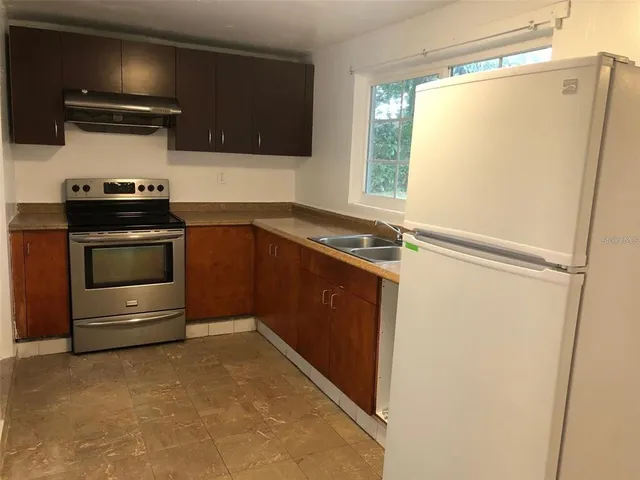 a kitchen with a refrigerator and a stove
