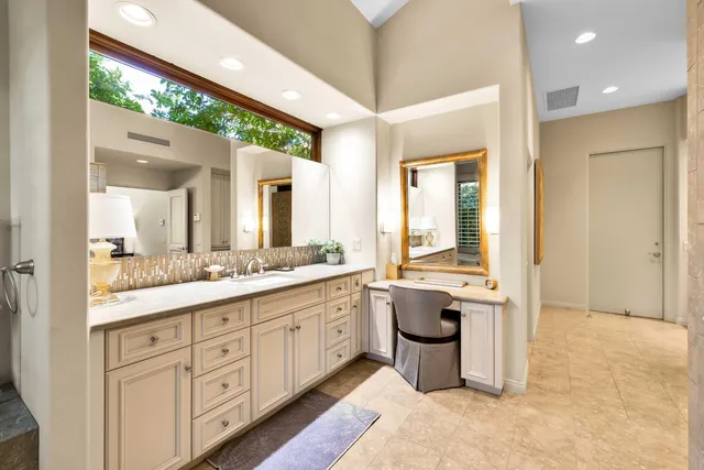 a bedroom with a bed couch and large windows