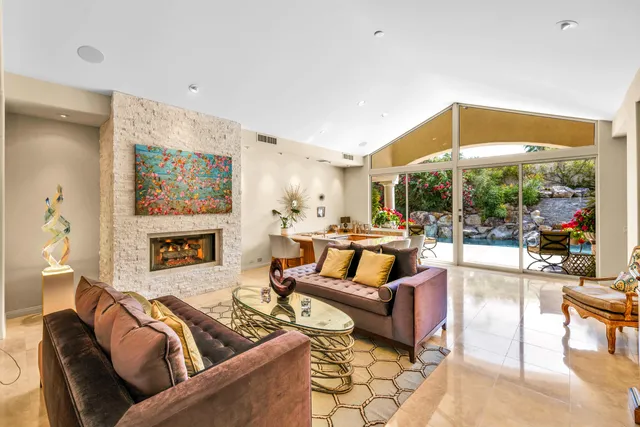 a living room with furniture kitchen view and a window