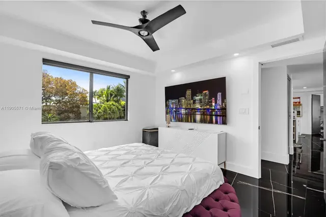 a bedroom with a bed a table and chair with the wooden floor