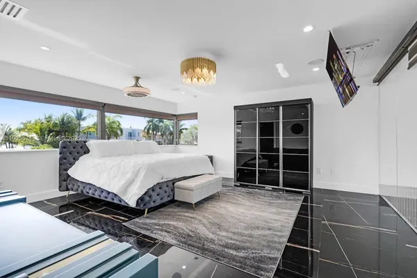 a living room with furniture a floor to ceiling window and a flat screen tv